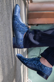 Blue Sassaniden echte Mascolori-schoenen in een 90 graden gedraaide, surrealistische fashionfoto
