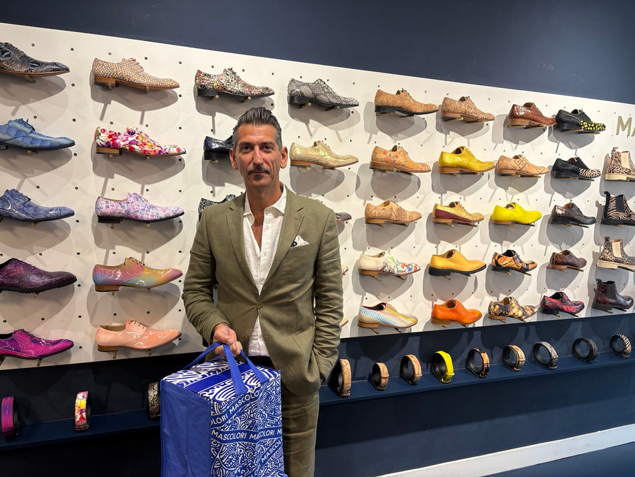 Mascolorist Danny Vera in de Mascolori-winkel bij de kleurrijke schoenenwand